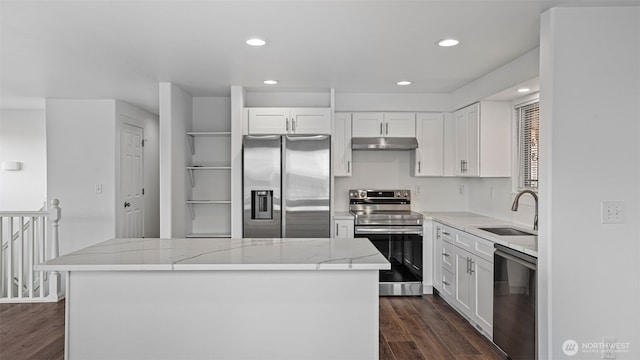 kitchen with dark wood-type flooring, under cabinet range hood, a sink, a center island, and appliances with stainless steel finishes