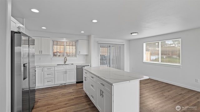 kitchen featuring a sink, a wealth of natural light, appliances with stainless steel finishes, and dark wood finished floors