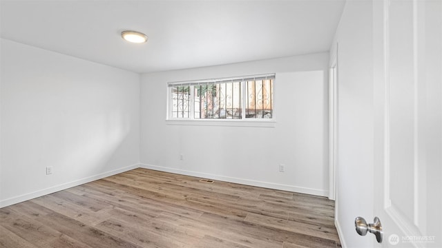 unfurnished room featuring visible vents, baseboards, and wood finished floors