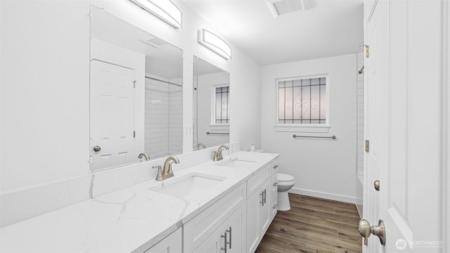 bathroom with a sink, visible vents, toilet, and wood finished floors