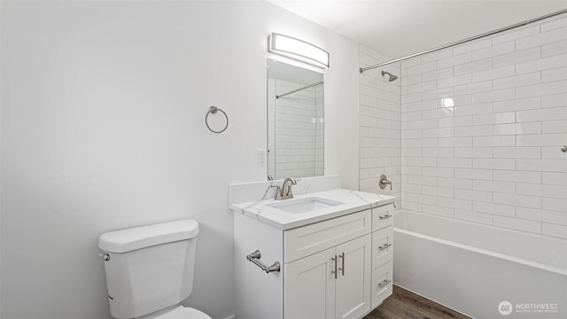 bathroom with vanity, toilet, wood finished floors, and tub / shower combination