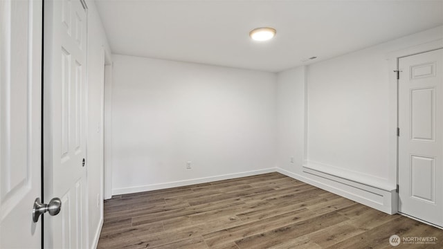 empty room featuring wood finished floors and baseboards