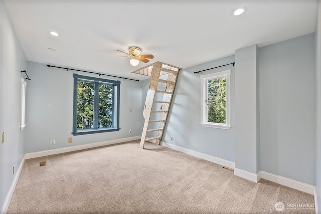 carpeted spare room with recessed lighting, a healthy amount of sunlight, ceiling fan, and baseboards