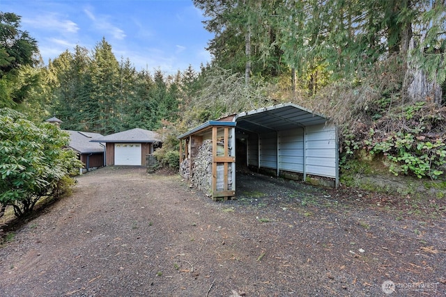 exterior space featuring a garage, an outbuilding, and a carport