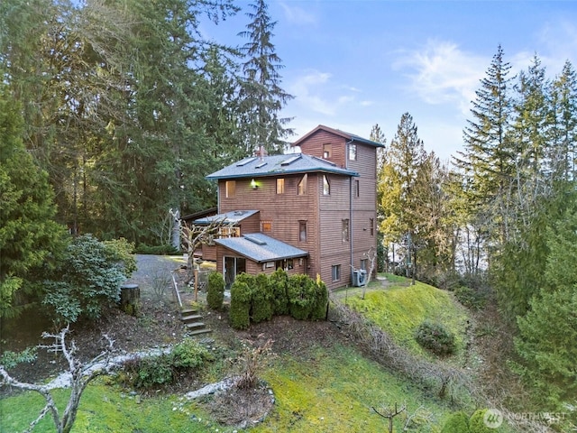 rear view of property with central AC and a chimney