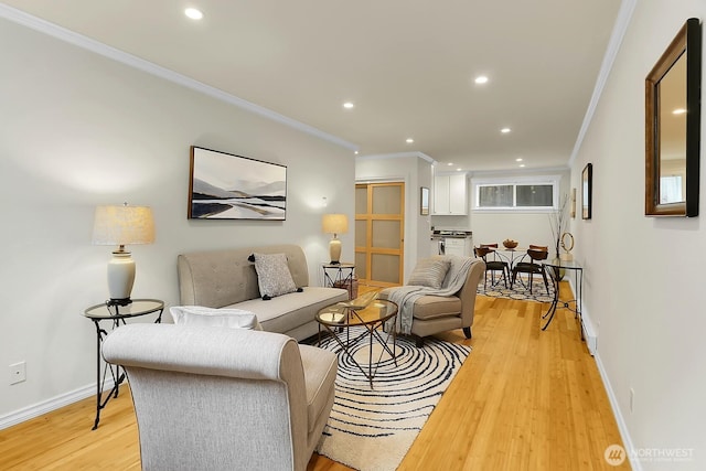 living room with light wood finished floors, ornamental molding, and recessed lighting