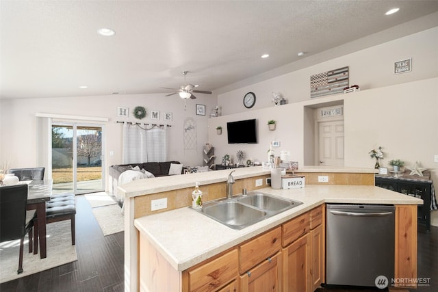 kitchen featuring open floor plan, vaulted ceiling, light countertops, stainless steel dishwasher, and a sink