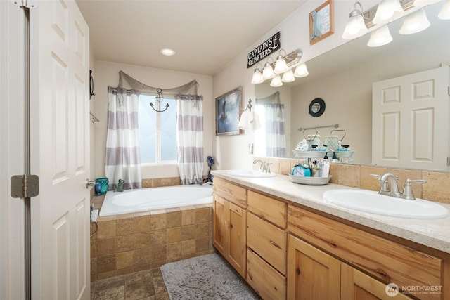 bathroom featuring tiled shower / bath, double vanity, and a sink