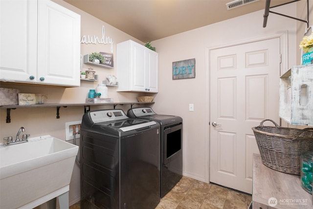 laundry area featuring cabinet space, visible vents, baseboards, washer and dryer, and a sink