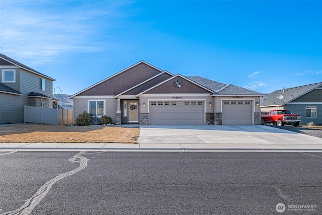 craftsman-style home with stone siding, fence, an attached garage, and concrete driveway