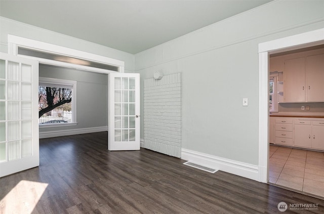 empty room with dark wood-style floors, visible vents, french doors, and baseboards