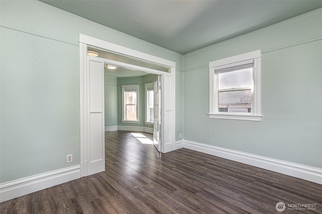 unfurnished room with dark wood-type flooring and baseboards