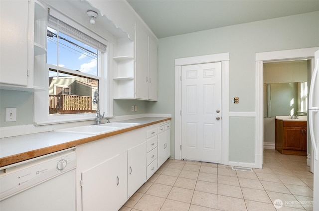 kitchen with white cabinets, open shelves, light countertops, and white dishwasher