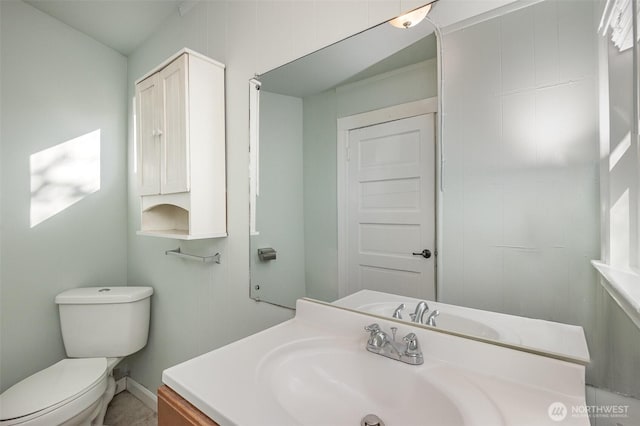 half bath featuring vanity and toilet