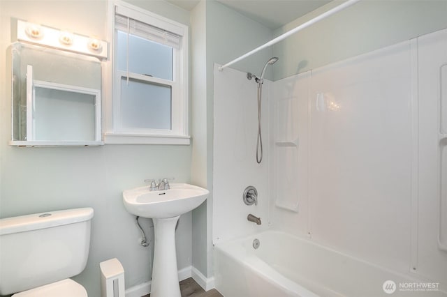 full bathroom with shower / tub combination, toilet, and baseboards