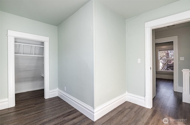 interior space with dark wood-type flooring, baseboards, and a closet