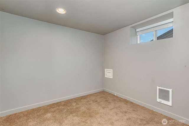 empty room featuring light carpet, heating unit, recessed lighting, and baseboards