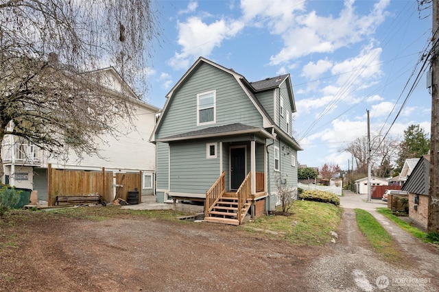 rear view of property featuring fence, a gambrel roof, entry steps, cooling unit, and driveway