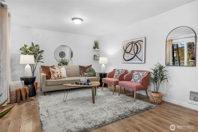 living room with baseboards, arched walkways, and wood finished floors