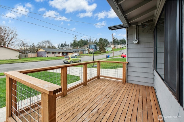 wooden terrace featuring covered porch, a residential view, and a yard