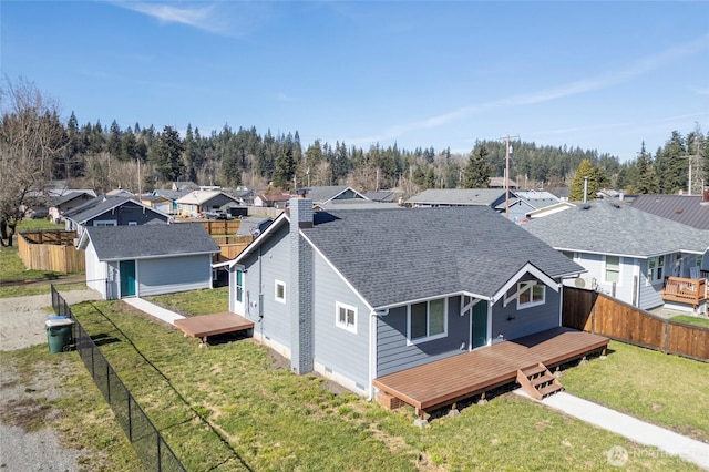 exterior space with a deck, an outbuilding, a fenced backyard, a yard, and a shed