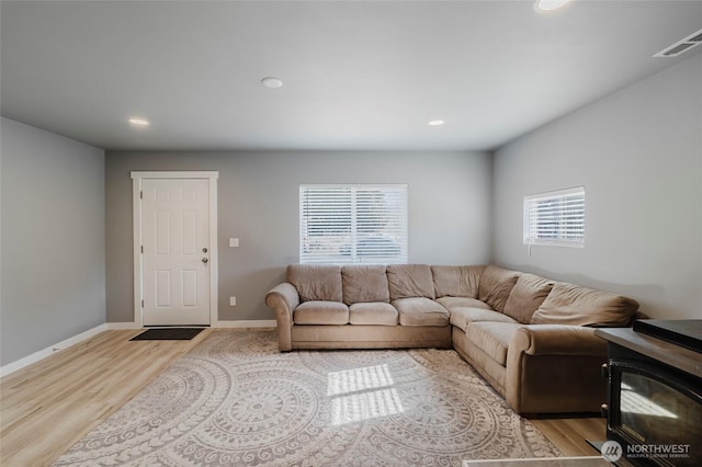 living area with recessed lighting, visible vents, baseboards, and wood finished floors