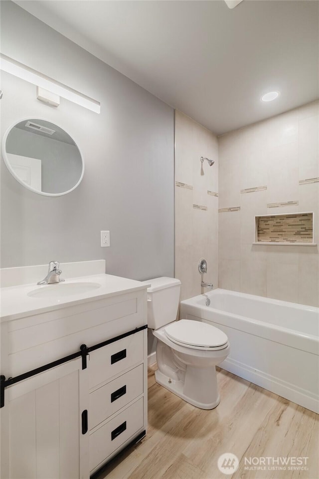 full bath featuring washtub / shower combination, vanity, toilet, and wood finished floors