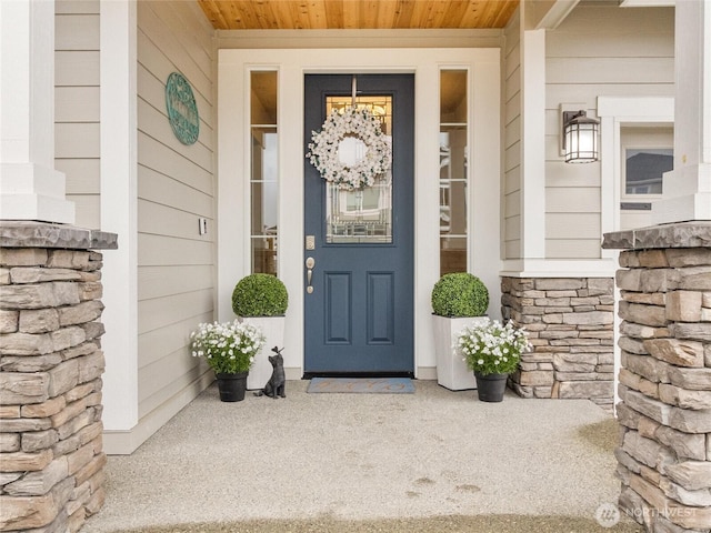 entrance to property featuring a porch and stone siding