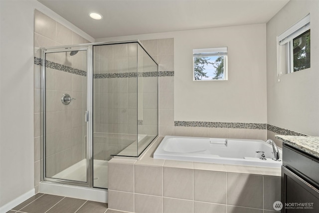 bathroom featuring a stall shower, vanity, and a bath