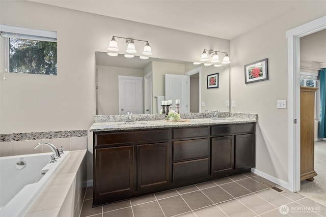 bathroom with visible vents, double vanity, a sink, and a bath