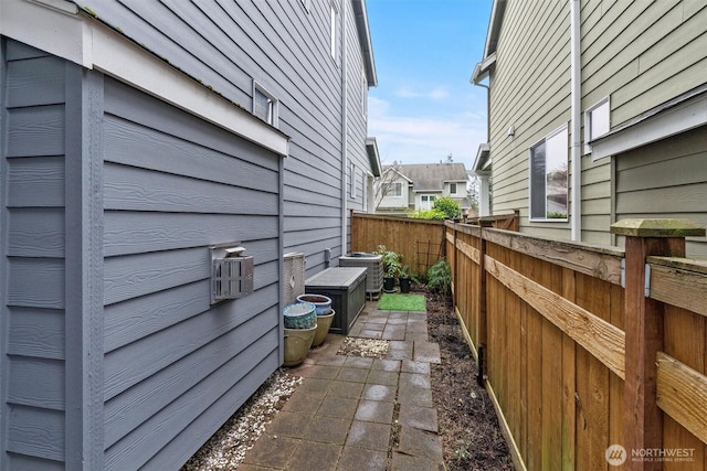 view of property exterior with fence and central AC