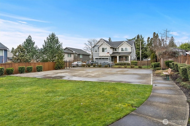 view of front of property featuring fence, a front lawn, and concrete driveway