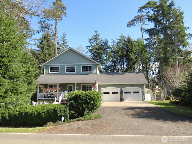 view of front facade with an attached garage, a porch, and driveway