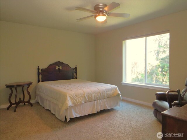 bedroom featuring a ceiling fan, light colored carpet, and baseboards