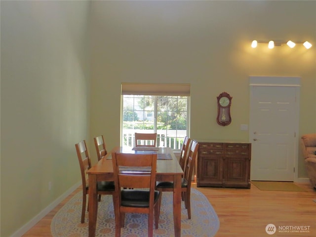 dining space with light wood-style flooring and baseboards