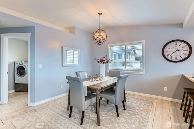 dining room featuring washer / clothes dryer, baseboards, plenty of natural light, and a chandelier