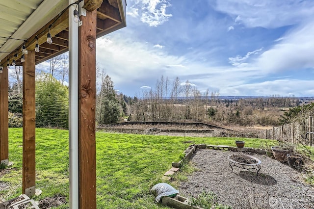 view of yard featuring an outdoor fire pit and fence