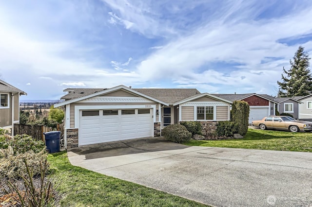 view of front of house with a front lawn, stone siding, fence, concrete driveway, and a garage