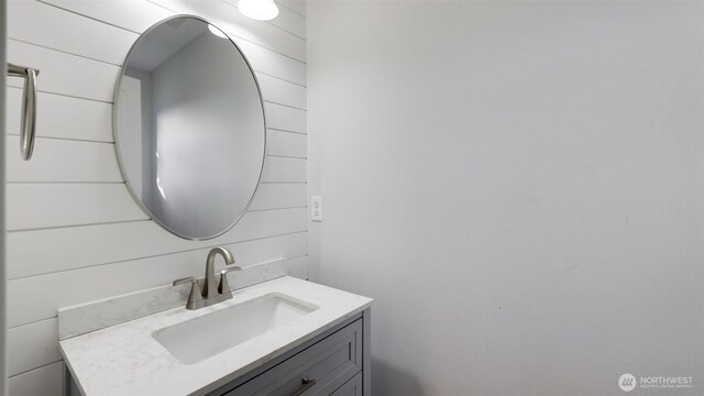 bathroom featuring wooden walls and vanity