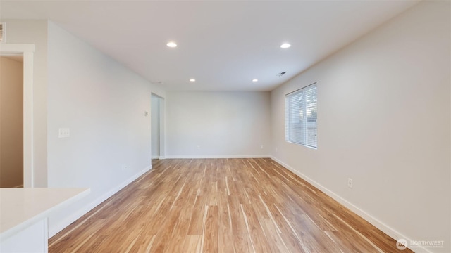 spare room with visible vents, recessed lighting, light wood-type flooring, and baseboards