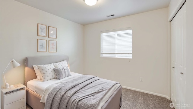 carpeted bedroom with baseboards, visible vents, and a closet