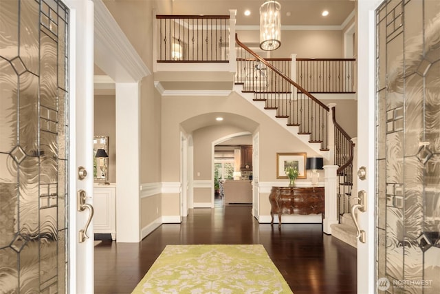 entrance foyer featuring stairway, a high ceiling, wood finished floors, and crown molding