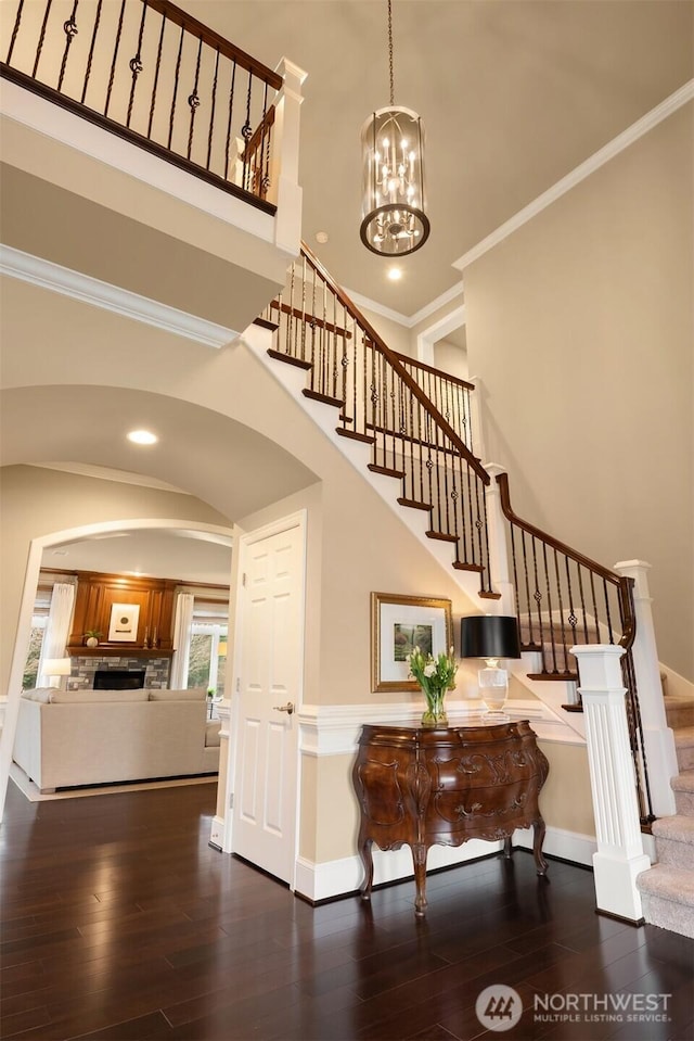 interior space with hardwood / wood-style floors, crown molding, and a towering ceiling