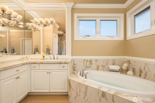 bathroom featuring a notable chandelier, vanity, a bath, and crown molding