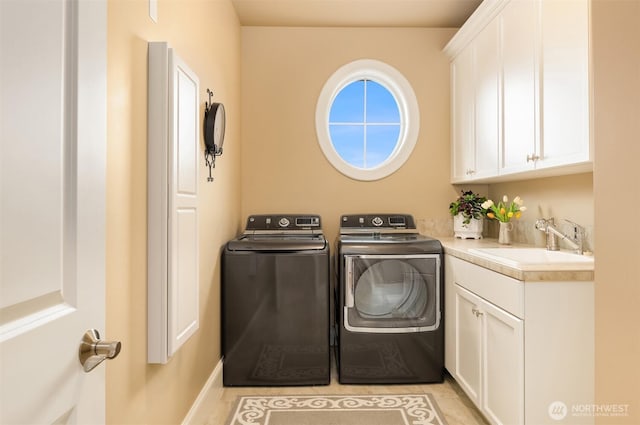 laundry room featuring a sink, cabinet space, and independent washer and dryer