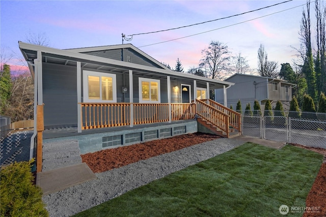 view of front of house with a porch, a front yard, a gate, and fence