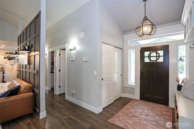 entrance foyer with a wealth of natural light, baseboards, high vaulted ceiling, and dark wood-style flooring