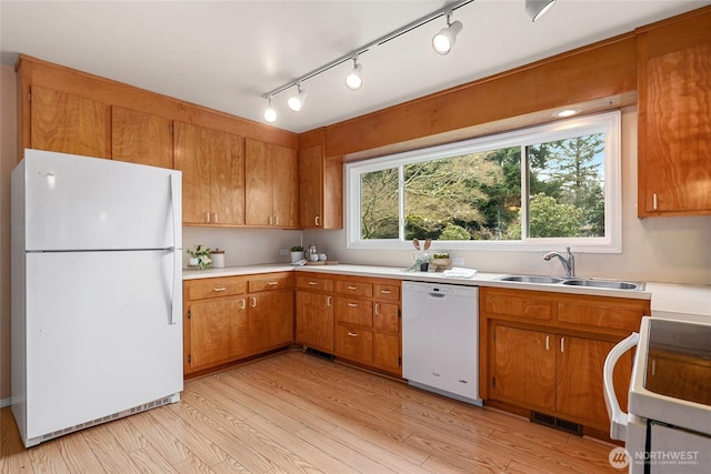 kitchen featuring white appliances, plenty of natural light, visible vents, light wood-style flooring, and a sink