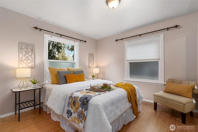 bedroom with baseboards and wood finished floors