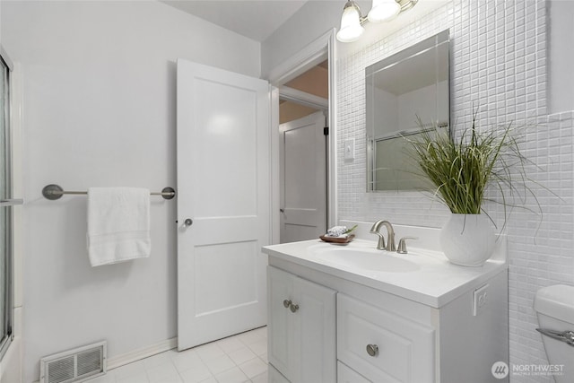 bathroom featuring a shower with shower door, vanity, visible vents, tile walls, and tile patterned floors